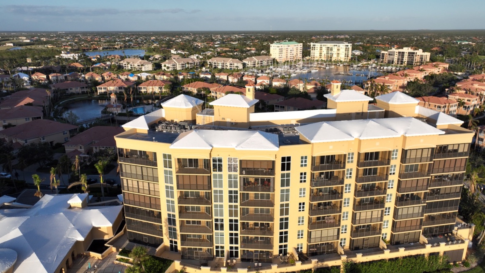 Condominium association buildings sealed under white Elastowrap roofs after a hurricane