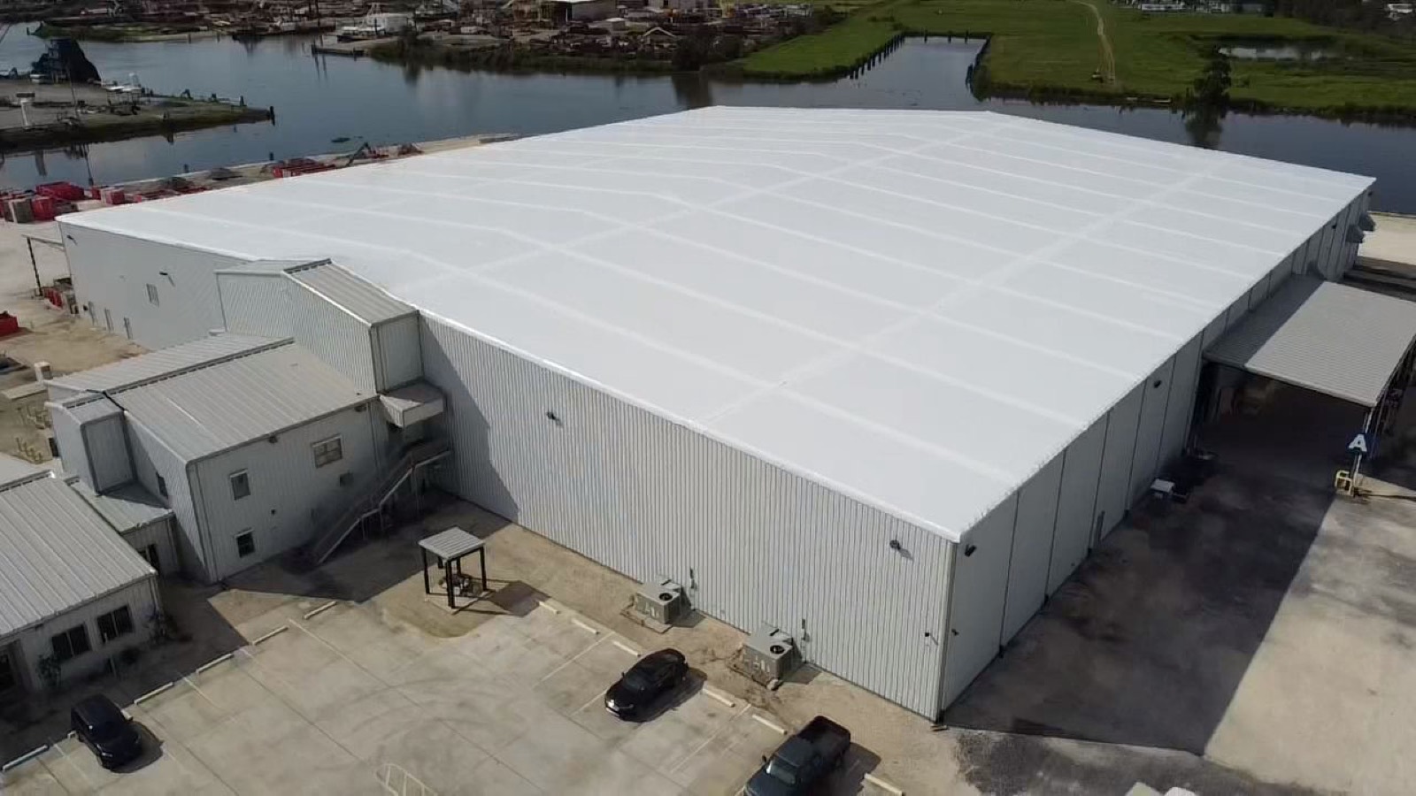 Industrial warehouse sealed under a white Elastowrap roof membrane