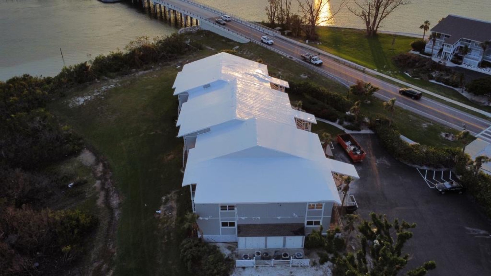 Long institutional building sealed under a continuous white Elastowrap roof