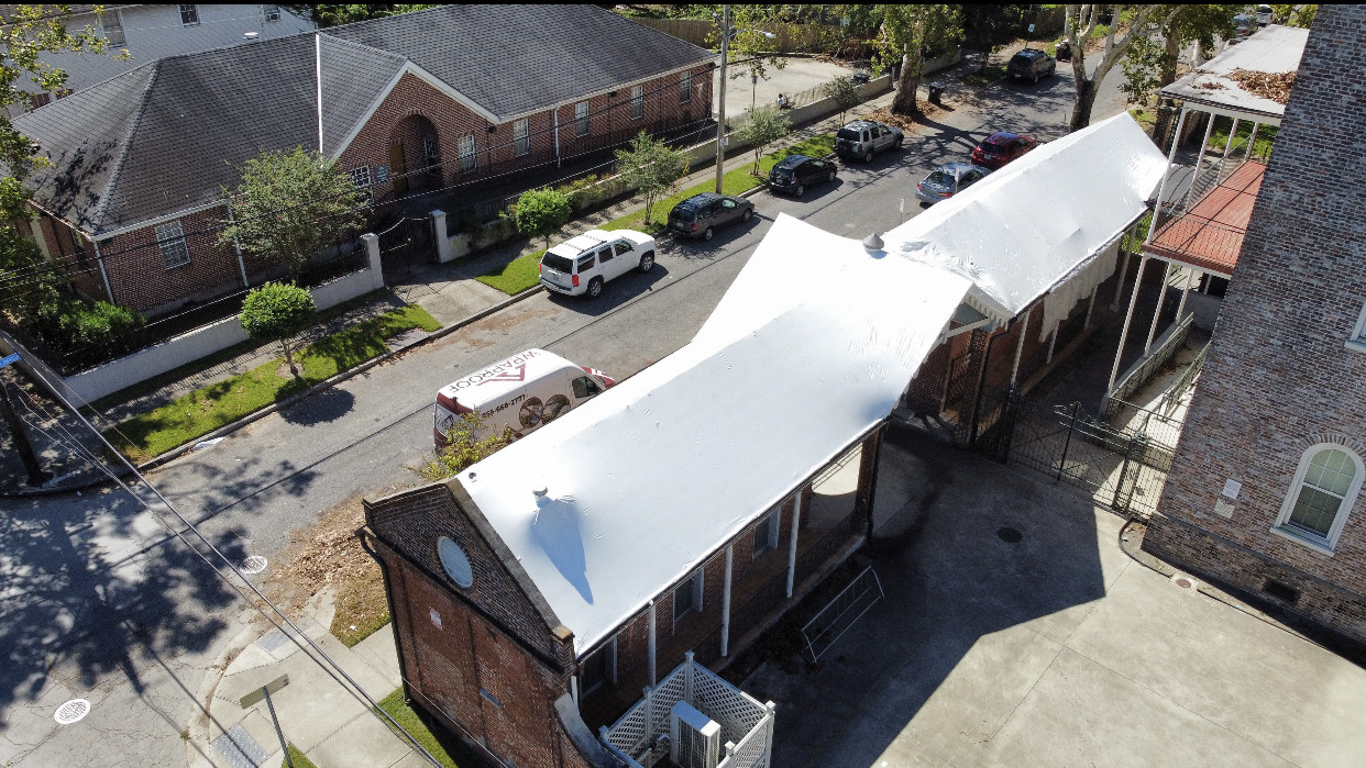 Municipal brick building on North Johnson Street sealed under a white Elastowrap roof