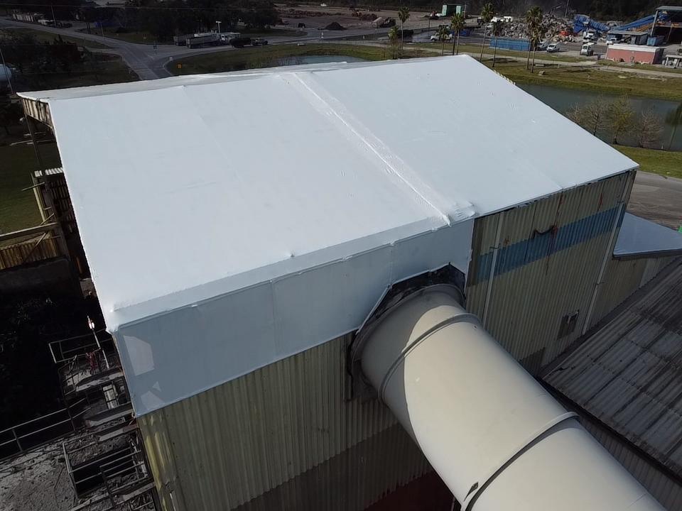 The same industrial recycling plant roof sealed under a white Elastowrap membrane