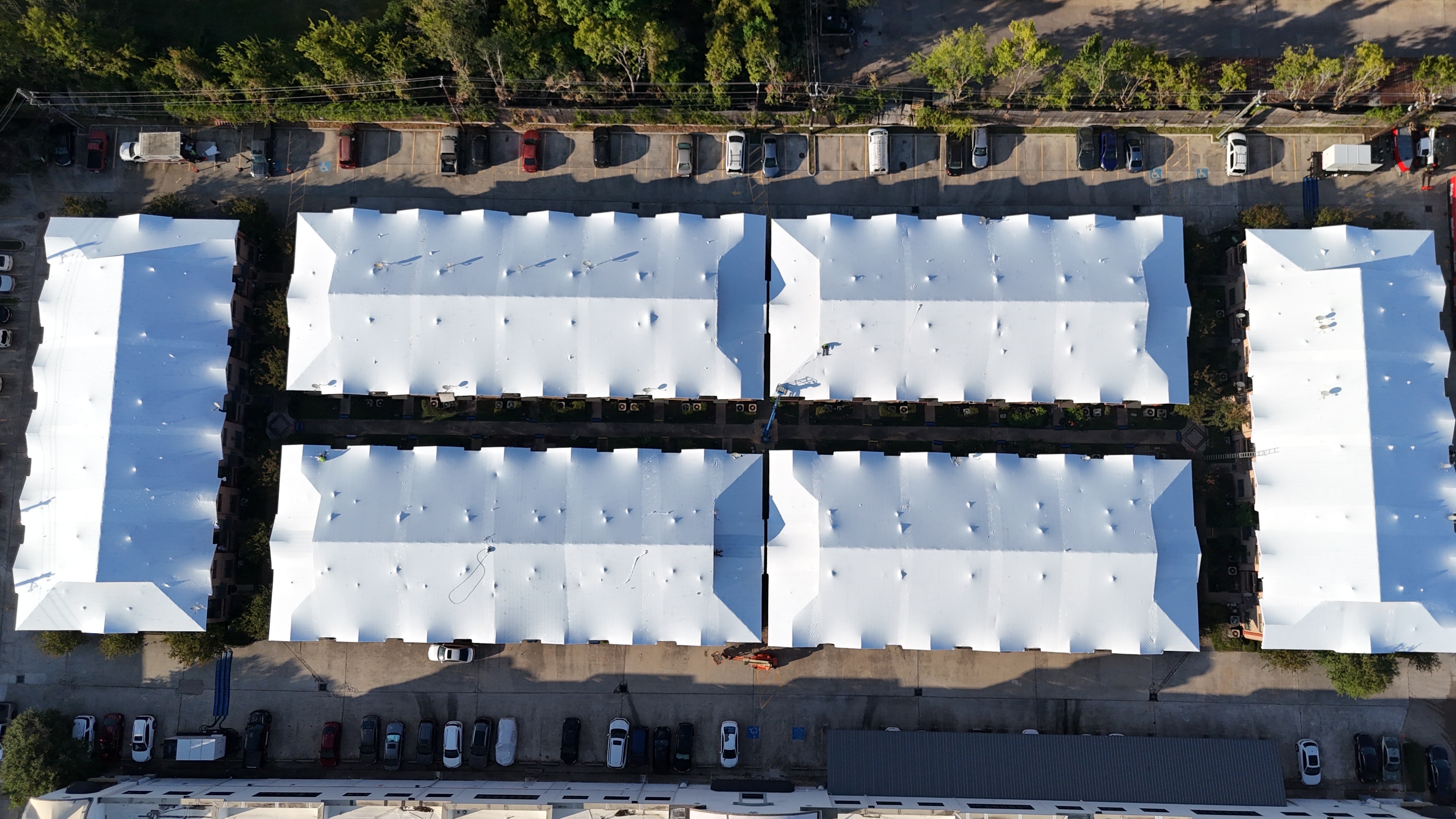 The same six building apartment complex sealed drum-tight under white Titanium Tarps Elastowrap roofs