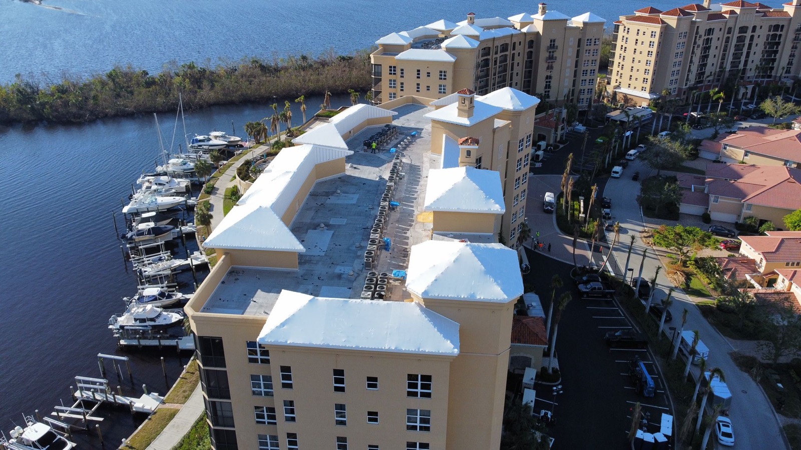 Waterfront condominiums and marina with white stretch wrapped roofs