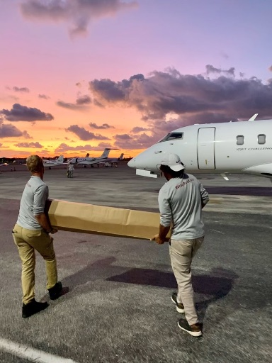 Crew and materials beside a chartered jet